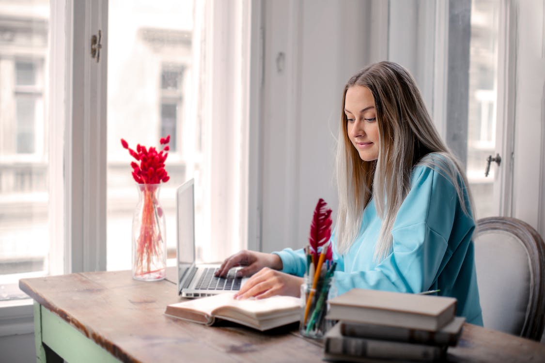 Free Woman in Blue Long Sleeve Shirt Sitting on Chair Stock Photo