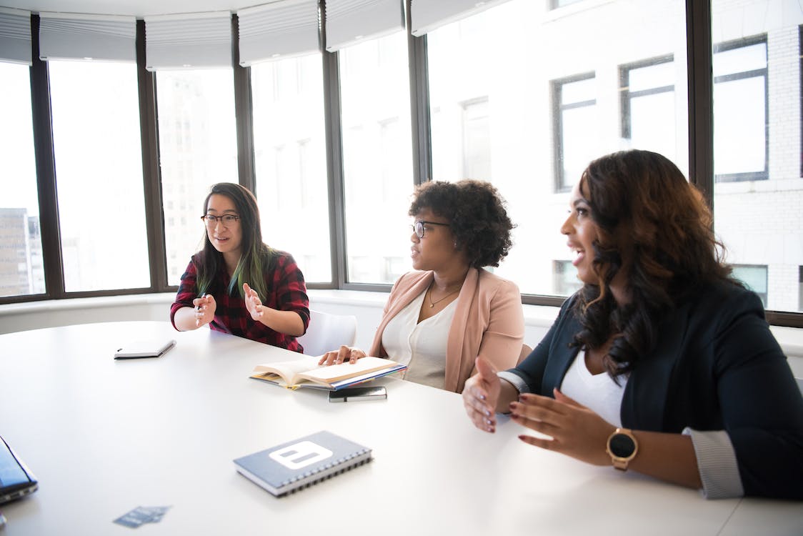 Free Three Woman Talking Near White Wooden Table Inside Room Stock Photo