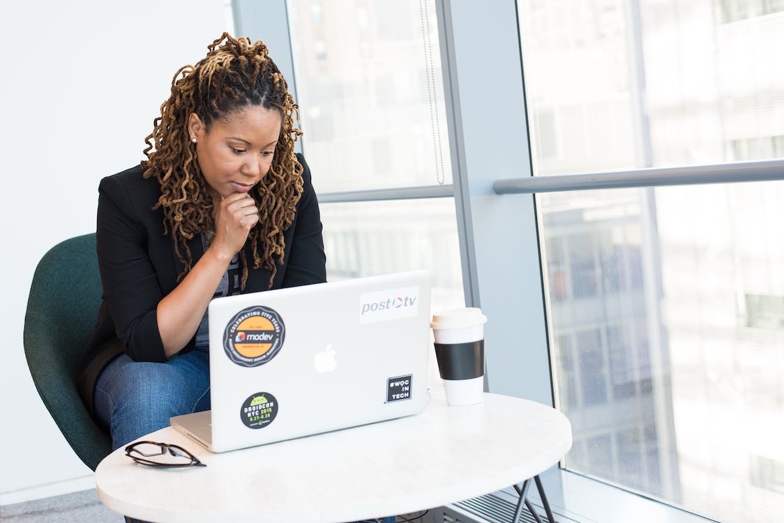 Free Woman in Black Coat in Front of White Laptop Computer Stock Photo