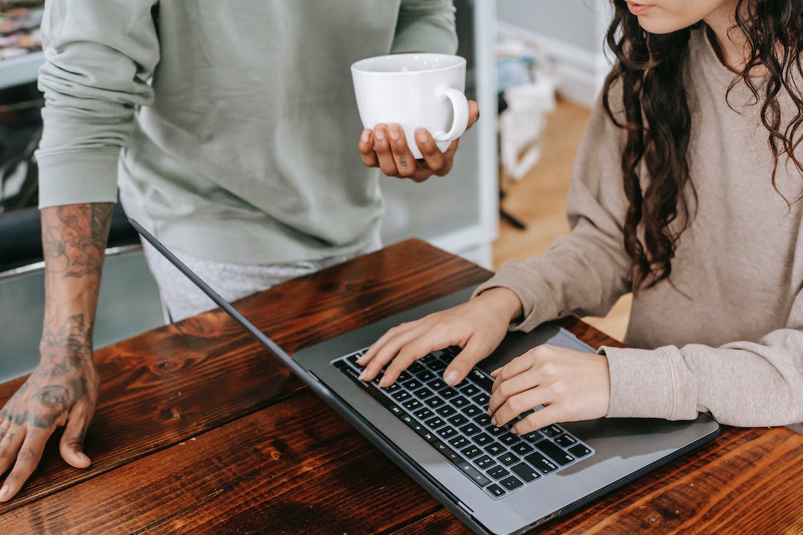 Free Woman In Brown Long Sleeve Shirt Using Macbook Pro Stock Photo